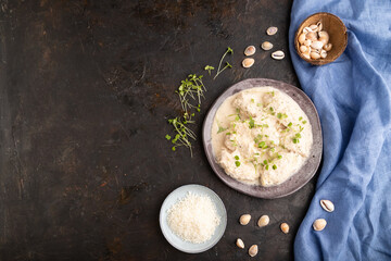Stewed chicken fillets with coconut milk sauce and rucola microgreen. top view, copy space.