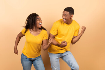 Obraz premium Having fun. Portarit of joyful black couple dancing and fooling around, enjoying favorite music together