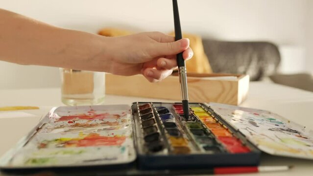 Child drawing with watercolor paint