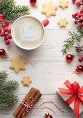 Cup of latte coffee and Christmas decoration on a white wooden background