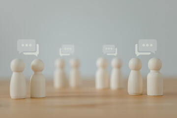 This is the idea: mingle, converse, and chat. Wooden dolls with speech bubbles on a white background