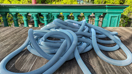 Spiral water hose that is placed carelessly and not arranged. Used to fill water in swimming pools....