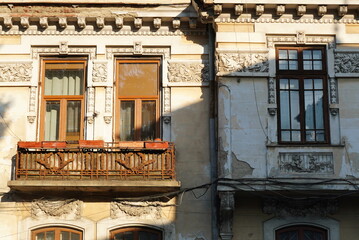 Facade of old house in neoclassical architectural style with floral decorations on frieze moldings...