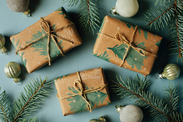 Christmas gift boxes, decoration and fir tree branch on blue background. Flat lay, top view