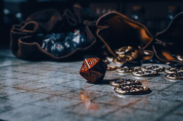Red RPG die on a gaming grid with game coins and dice bags