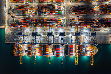 Aerial top view Container yard in the harbor area, Container ship working at night.