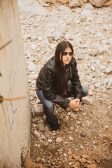 Woman with classic sunglasses on a cloudy day, dressed in a black leather jacket