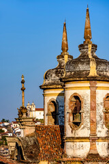 Bell tower of baroque churches at dusk with the famous historic city of Ouro Preto in the background