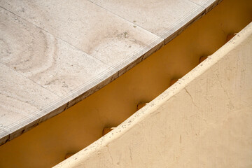 Astronomical Observatory at Jantar Mantar in Jaipur, India. Geometric shapes of architecture isolated against blue sky background. Astronomical calculating instrument measures longitude and latitude.