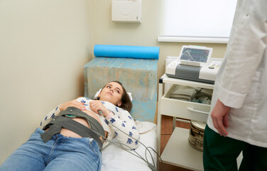 Happy pregnant female visiting her own gynecologist in medical clinic.Doctor examining the baby...