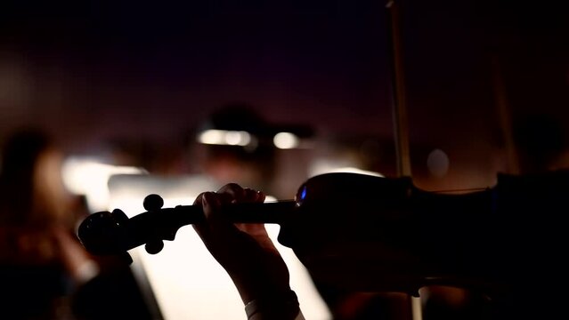 Close-up of a violin during a musician performance in the classical music concert hall