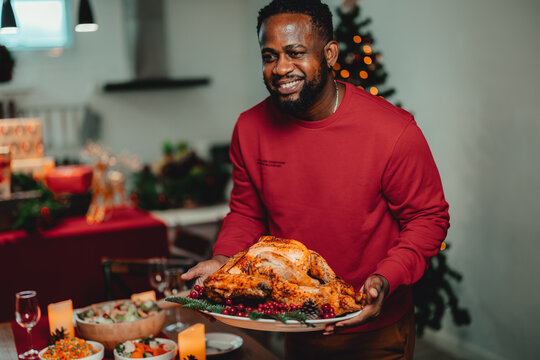A man is holding a christmas turkey dinner plate ready to be eaten on the table.