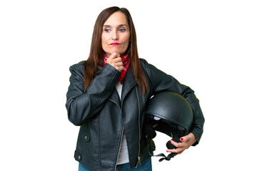 Middle age caucasian woman with a motorcycle helmet over isolated chroma key background having doubts and thinking