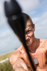 male vandal with a dirty naked torso and with a mace in his hand, swings to strike