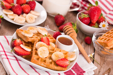 Waffles with strawberries, bananas and honey.