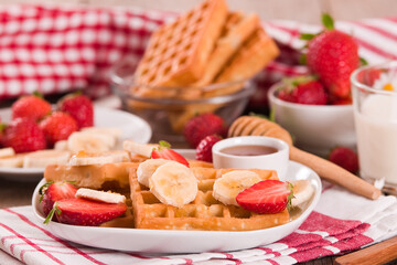 Waffles with strawberries, bananas and honey.