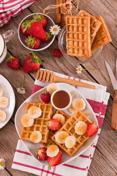 Waffles with strawberries, bananas and honey.