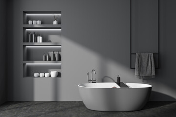 Fototapeta na wymiar Grey bathroom interior with bathtub and accessories. Copy space