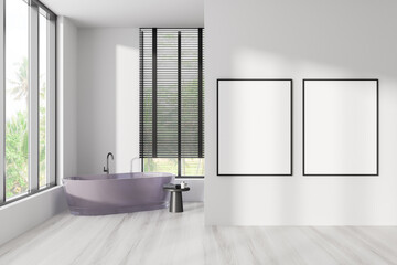 Fototapeta na wymiar Bright bathroom interior with bathtub, two empty white posters