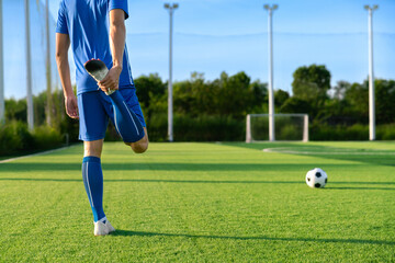 football soccer player stretching during warm up before kick ball in football match league in...