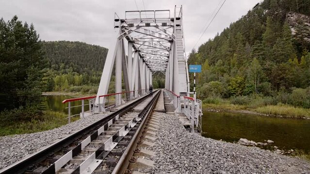 Hiking. Crossing the railway bridge over the river.