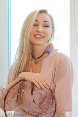 Portrait of pretty girl in crown chakra tassel earrings and necklace, silk robe