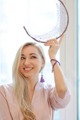 Portrait of pretty girl in crown chakra tassel earrings and necklace, silk robe