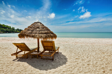 Fototapeta premium Vacation holidays beach concept - Two beach lounge chairs under tent on beach. Sihanoukville, Cambodia