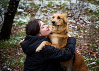 woman hugging dog in winter park