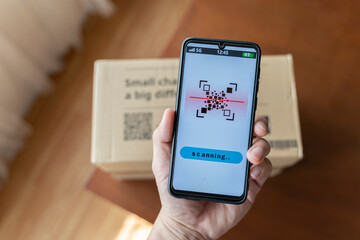 close up of man with smartphone scanning QR code. Barcodes on parcels at the post office