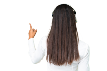 Telemarketer African American woman working with a headset over isolated chroma key background pointing back with the index finger