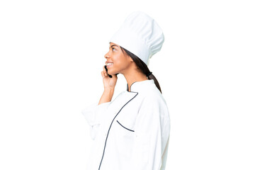 Young African American chef over isolated chroma key background keeping a conversation with the mobile phone with someone