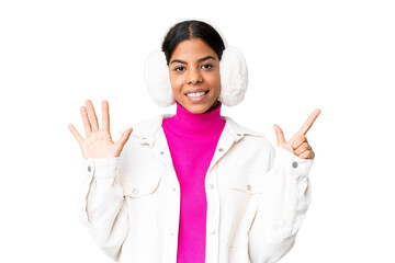 Young African American woman wearing winter muffs over isolated chroma key background counting...