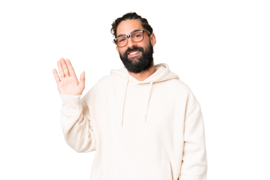 Young man with beard over isolated chroma key background saluting with hand with happy expression