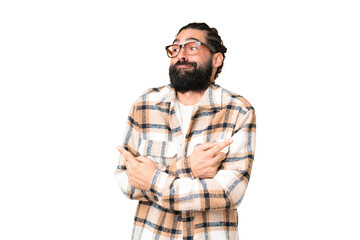 Young man with beard over isolated chroma key background pointing to the laterals having doubts