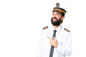 Airplane caucasian pilot man over isolated chroma key background pointing to the side to present a product