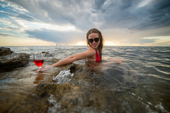 A young, beautiful woman relaxes in the water of the Adriatic Sea in Croatia