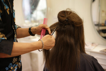 Fototapeta premium 女性の髪を切る男性美容師