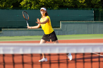 Woman playing tennis and waiting for the service.