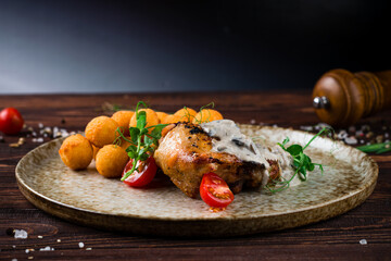 Fried chicken thigh with mushroom sauce and croquettes, fried mashed potato balls with tomatoes and...