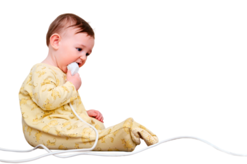 Toddler baby boy gnaws electrical wires while sitting on the floor, isolated on a white background. Child holding an extension cord with electrical sockets, copy space. Kid nine months old
