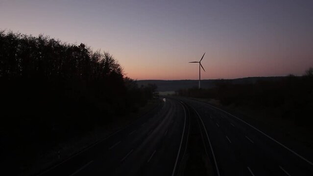Time lapse of a morning sunrise over the Highway with a winmill in the background