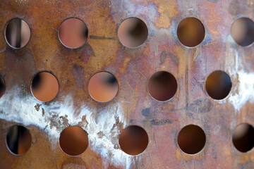 Antique rusty copper flower vase. There is a drainage hole on the side. Close up macro texture photograph.