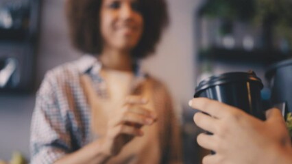 Friendly woman barista serving coffee to go in cafe, small business owner