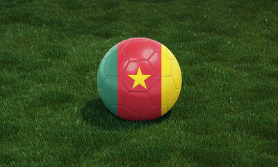Soccer ball with Cameroon flag colors at a stadium on green grasses background.