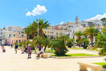 Vieste, Italy. View of the square at the promenade of Viale Marinai D'Italia in the town center. You can see palm trees and people walking by. September 5, 2022. - obrazy, fototapety, plakaty
