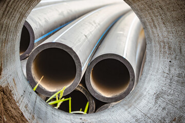 Water pipes for drinking water supply at a construction site. Underground pipeline works. Modern water supply systems for a residential city. Water supply at home. View from the big pipe.