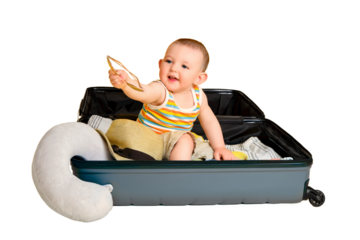 Baby toddler boy sits inside a suitcase with clothes, studio isolated on white background. A child plays in a big bag while packing luggage for a vacation trip. Kid age one year (12 months)