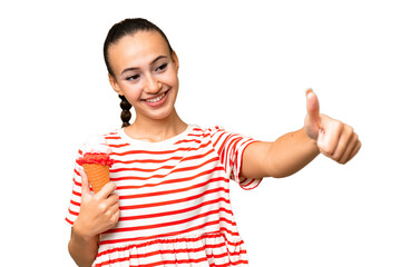 Young Arab woman with a cornet ice cream over isolated background giving a thumbs up gesture