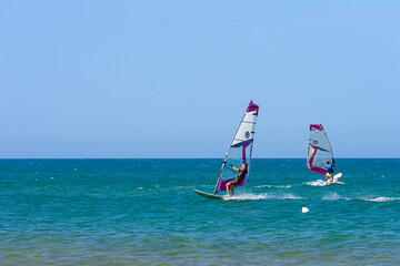 Vieste, Italy. In the sea of Vieste, near the Scialmarino beach, two people practice windsurfing....